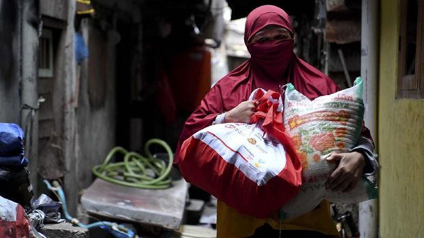 Warga membawa paket bantuan sosial dari pemerintah yang ia terima di kawasan Koja, Jakarta, Sabtu (2/5/2020). Kementerian Sosial akan menyalurkan 1,8 juta paket bantuan Khusus Presiden ke masyarakat di wilayah Jakarta, Bogor, Depok, Tangerang, dan Bekasi (Jabodetabek).  ANTARA FOTO/Hafidz Mubarak A/hp.