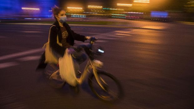 In this photo taken on Saturday, April 25, 2020, a woman rides a Madrid's electric bike hire service BiciMAD as the lockdown to combat the spread of coronavirus continues in downtown Madrid, Spain. As countries across the world seek to get their economies back on track after coronavirus lockdowns are over, some people are encouraging the use of bicycles as a way to avoid unsafe crowding on trains and buses. (AP Photo/Manu Fernandez)