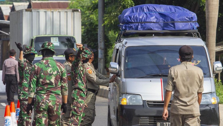 Petugas gabungan mengarahkan pemudik roda empat dari arah Bekasi menuju Karawang untuk berputar arah di Perbatasan Karawang - Bekasi, Jawa Barat, Jumat (24/4/2020). Penyekatan akses transportasi di perbatasan tersebut sebagai tindak lanjut kebijakan larangan mudik yang berlaku bagi kendaraan pribadi, angkutan umum dan motor kecuali mobil pemadam kebakaran, angkutan logistik dan kebutuhan pokok serta ambulan. ANTARA FOTO/M Ibnu Chazar/pras.