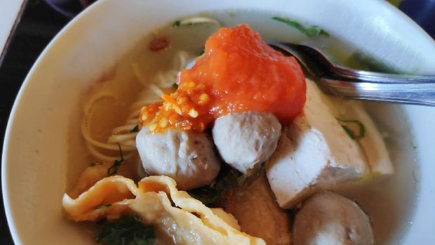 Bakwan Bakso Malang / Surabaya. East Javanese comfort food of steamed meatballs, bean curd, fried meatballs and wonton in hot beef broth with condiments of celery, spring onions, shallots, and spicy sauces