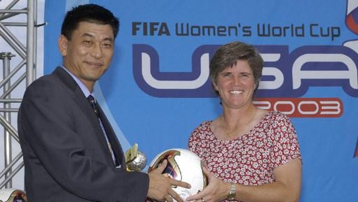 Ma Liangxiang (L), the head coach of the Chinese Womens National Soccer team, passes the ball to U.S. Womens National Soccer Team head coach April Heinrichs in a ritual to the host country prior to the FIFA Womens World Cup USA 2003 Draw 17 July, 2003 at the Home Depot Center in Carson, California. The 16 qualified teams were divided into four groups of four teams each. AFP PHOTO/VINCE BUCCI (Photo by VINCE BUCCI / AFP)