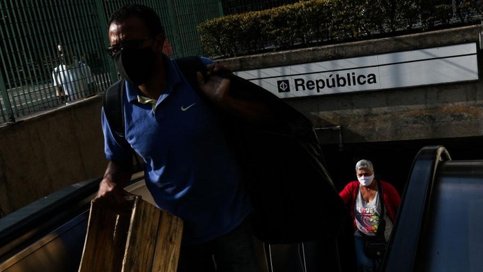 Seorang penumpang dengan mengenakan masker berjalan di stasiun kereta bawah tanah di tengah-tengah pandemi COVID-19 pada 4 Mei 2020 di Sao Paulo, Brasil.