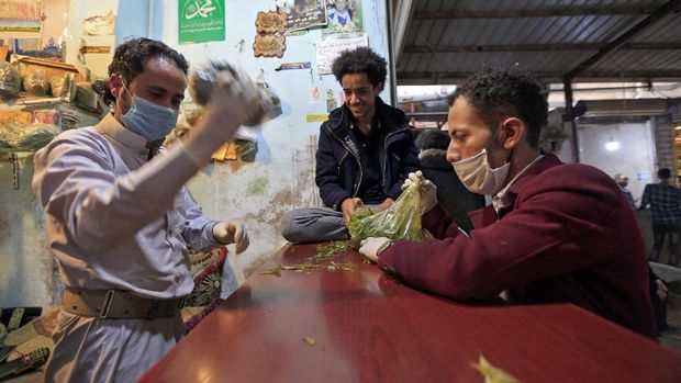 A Yemeni man buys qat, the ubiquitous mild narcotic, at a market in the capital Sanaa on May 1, 2020. - While most of the world's markets have closed to curb the spread of coronavirus, in Yemen's capital Sanaa, downtown districts selling qat -- the ubiquitous mild narcotic -- still bustle with people. Flouting social distancing rules, Yemenis jostle to select bunches of the chewable leaf from vendors packed into the narrow laneways crowded with stalls. (Photo by Mohammed HUWAIS / AFP)