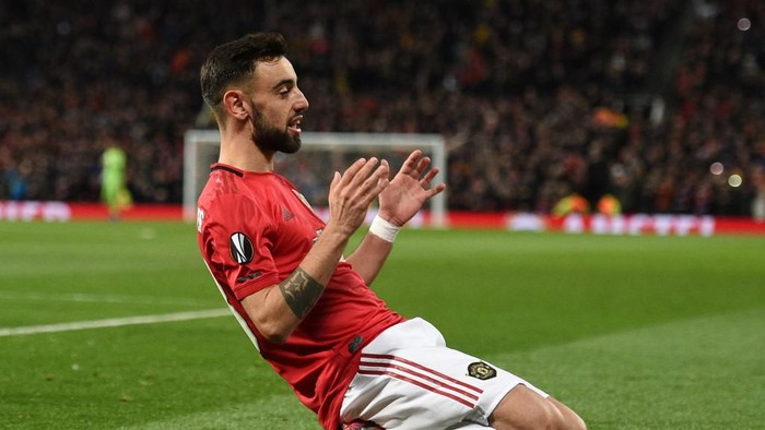 Manchester Uniteds Portuguese midfielder Bruno Fernandes celebrates scoring his teams first goal during the UEFA Europa League round of 32 second leg football match between Manchester United and Club Brugge at Old Trafford in Manchester, north west England, on February 27, 2020. (Photo by Oli SCARFF / AFP)