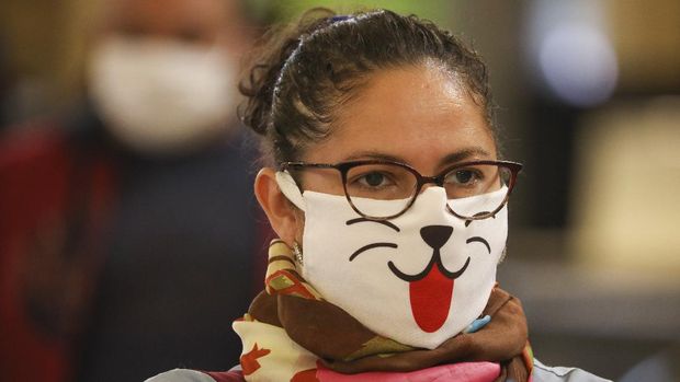 A woman wearing a face mask decorated with an animal face waits in line for a rapid coronavirus test at a train station in Buenos Aires, Argentina, Friday, April 24, 2020. (AP Photo/Natacha Pisarenko)