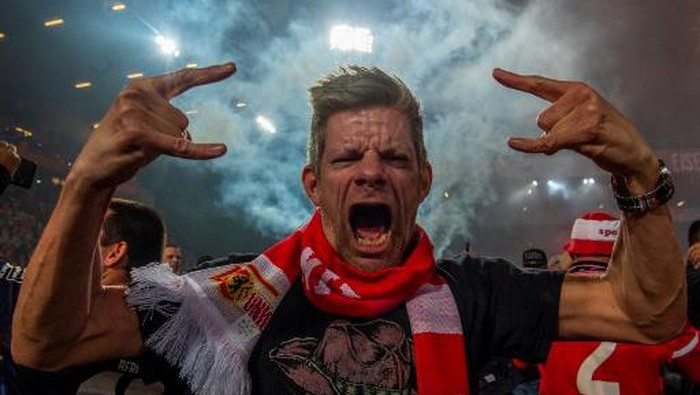 An Union Berlin supporter celebrates on the pitch after Union won in the German Bundesliga Relegation second-leg football match FC Union Berlin v VfB Stuttgart in Berlin, on May 27, 2019. (Photo by John MACDOUGALL / AFP) / DFL REGULATIONS PROHIBIT ANY USE OF PHOTOGRAPHS AS IMAGE SEQUENCES AND/OR QUASI-VIDEO