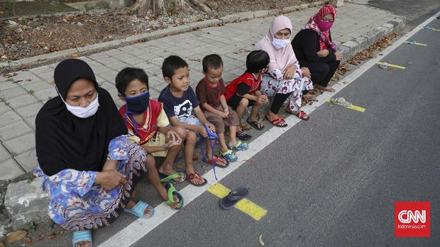 Warga antre mengambil takjil yang disediakan pengurus RT 005 RW 006 kawasan Cempaka Putih Raya,Jakarta, Selasa, 12 Mei 2020. CNNIndonesia/Safir Makki