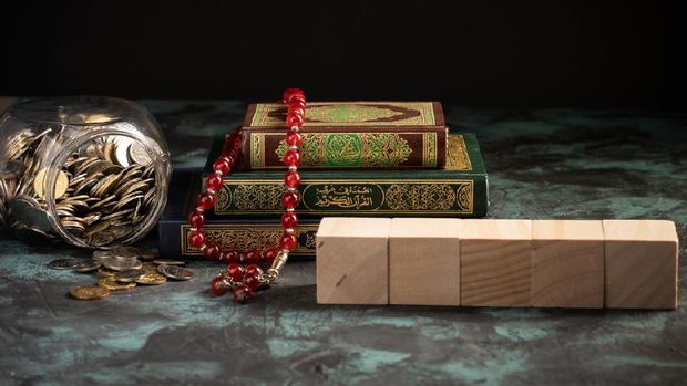 Islamic concept: The holy Quran and Tasbih (rosary beads) on dark background