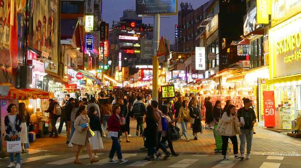 Hongdae Seoul, South Korea - April 7, 2019: Tourists and local people are shopping and walking at hongdae street market at night. Hongdae is a shopping cultural street for young people in Seoul.