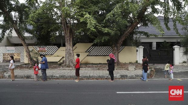 Warga antre mengambil takjil yang disediakan pengurus RT 005 RW 006 kawasan Cempaka Putih Raya,Jakarta, Selasa, 12 Mei 2020. CNNIndonesia/Safir Makki