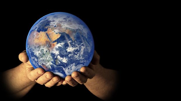 Earth (East view) in male hands isolated on a black background. Space for copy. Earth globe image provided by NASA - https://earthobservatory.nasa.gov/images/84214/blue-marble-eastern-hemisphere