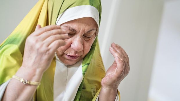 Portrait of an elderly Muslim woman praying