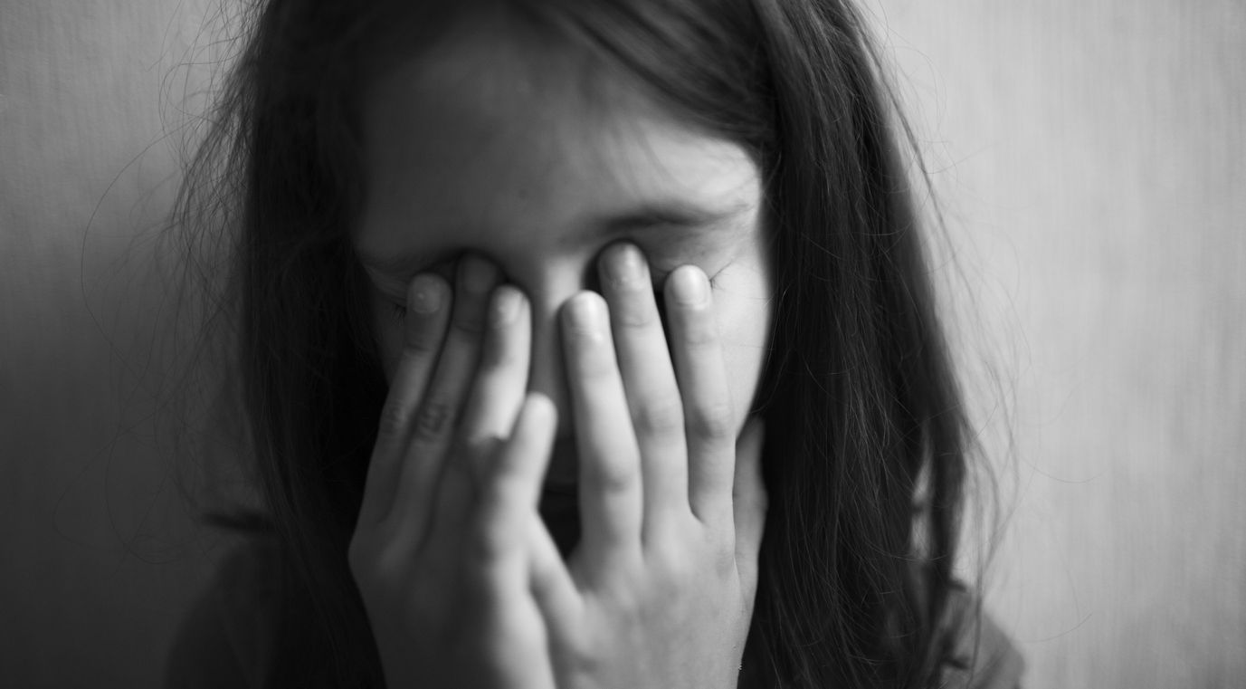 Little girl covers her face with hands isolated