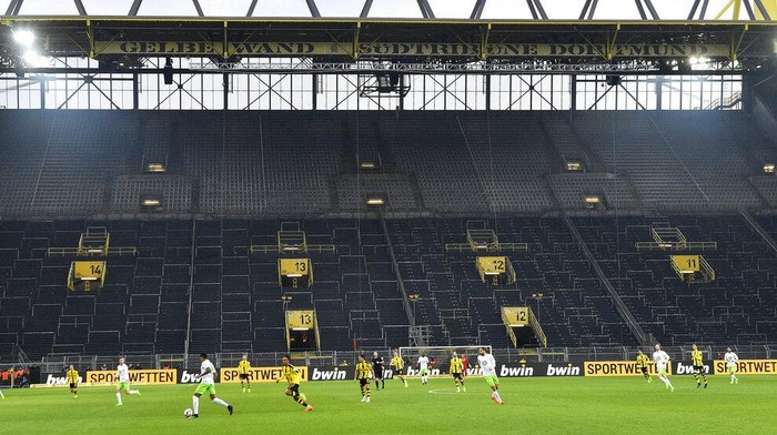 FILE - In this Feb. 18, 2017 file photo, players challenge for the ball in front of the empty south tribune because of a ban following fan trouble during the German Bundesliga soccer match between Borussia Dortmund and VfL Wolfsburg at Germanys biggest stadium in Dortmund, Germany. Bundesliga will now restart on May 16, 2020 when Dortmund will play the derby against Schalke at home without spectators due to the coronavirus outbreak. (AP Photo/Martin Meissner, file)