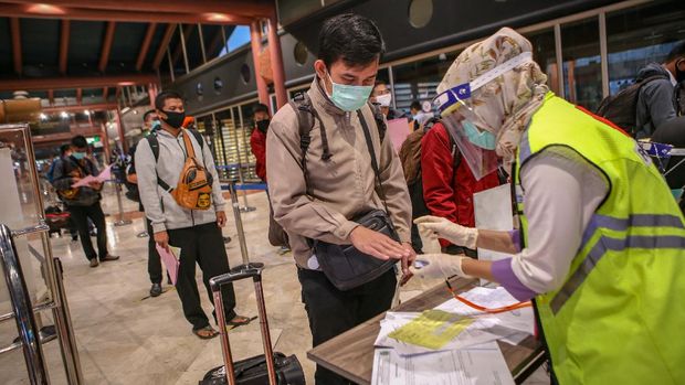 Petugas memeriksa kesehatan calon penumpang sebelum pemberangkatan di Terminal 2 Bandara Soekarno Hatta, Tangerang, Banten, Jumat (15/5/2020). Sebanyak 1486 penumpang berizin dengan 23 penerbangan diterbangkan dari Bandara Soekarno Hatta dengan dokumen syarat terbang dan surat keterangan bebas COVID-19. ANTARA FOTO/Fauzan/pras.