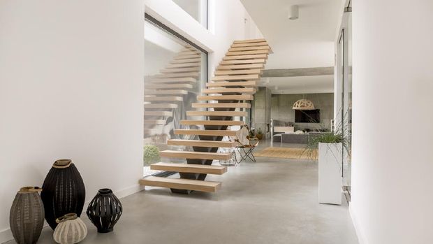 Modern two floor apartment with wooden stairs and living room open to kitchen