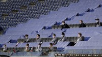 Para pemain cadangan duduk berjauhan bahkan mereka harus duduk di tribun penonton. Michael Probst/Pool via Getty Images.