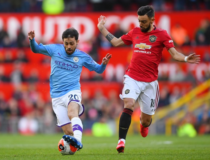 MANCHESTER, ENGLAND - MARCH 08: Bernardo Silva of Manchester City battles for possession with Bruno Fernandes of Manchester United  during the Premier League match between Manchester United and Manchester City at Old Trafford on March 08, 2020 in Manchester, United Kingdom. (Photo by Laurence Griffiths/Getty Images)
