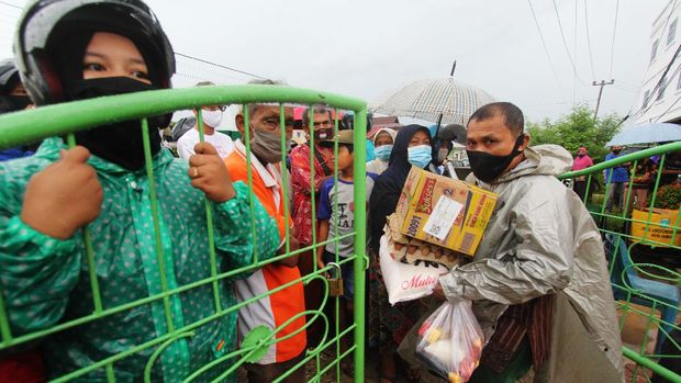 Seorang warga membawa paket sembako bansos yang diserahkan petugas kelurahan menjelang penerapan pembatasan sosial berskala besar (PSBB) di Kota Dumai, Riau, Minggu (17/5/2020). Dinas sosial setempat pada tahap pertama H-1 PSBB menyalurkan bansos sembako sebanyak 14 ribu paket kepada keluarga nondata terpadu kesejahteraan sosial (DTKS) di Kota Dumai yang penganggarannya bersumber dari keuangan daerah. ANTARA FOTO/Aswaddy Hamid/aww.