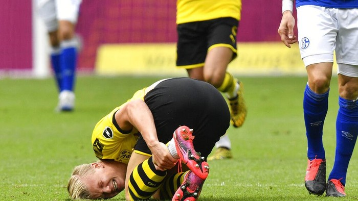 Dortmunds Erling Haaland grimaces after being fouled during the German Bundesliga soccer match between Borussia Dortmund and Schalke 04 in Dortmund, Germany, Saturday, May 16, 2020. The German Bundesliga becomes the worlds first major soccer league to resume after a two-month suspension because of the coronavirus pandemic. (AP Photo/Martin Meissner, Pool)