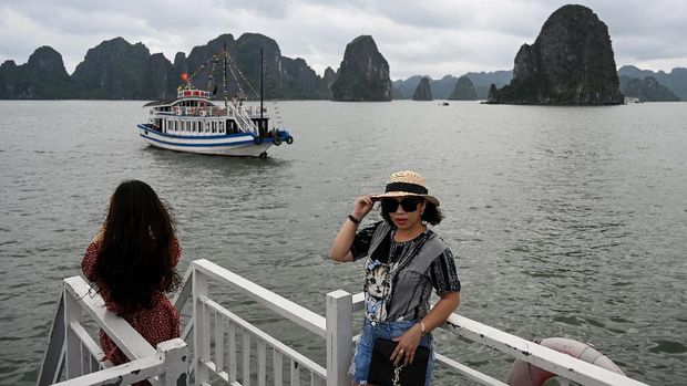 Local tourists pose for photographs on a boat in the midst of Ha Long Bay in northeastern province of Quang Ninh on May 16, 2020. (Photo by Manan VATSYAYANA / AFP)