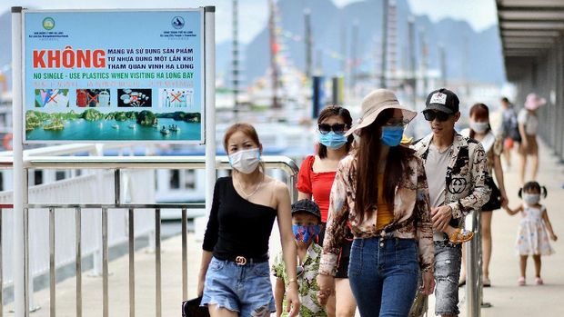 Local tourists wearing face masks leave a pier after returning from a cruise trip in the waters of Ha Long Bay in northeastern province of Quang Ninh on May 16, 2020. (Photo by Manan VATSYAYANA / AFP)