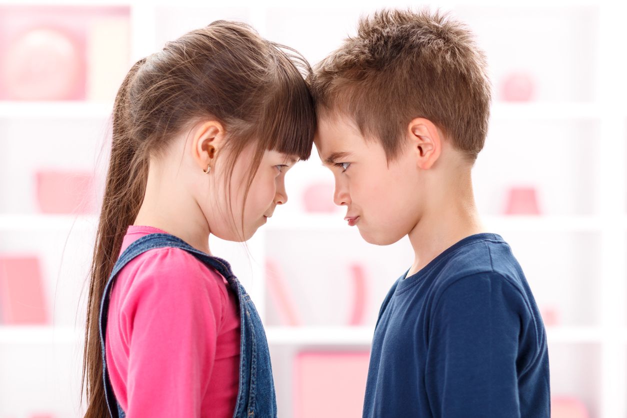 Angry kids after quarrel looking at each other