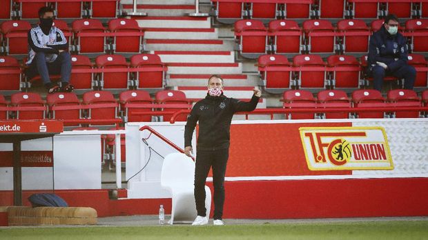 Coach Hansi Flick of Munich gestures during the German Bundesliga soccer match between Union Berlin and Bayern Munich in Berlin, Germany, Sunday, May 17, 2020. The German Bundesliga becomes the world's first major soccer league to resume after a two-month suspension because of the coronavirus pandemic. (AP Photo/Hannibal Hanschke, Pool)