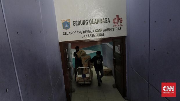 Relawan Gugus Tugas Percepatan Penanganan Covid-19 memindahkan kotak berisi sembako di GOR Gelanggang Remaja, Jakarta, Selasa (18/5/2020)