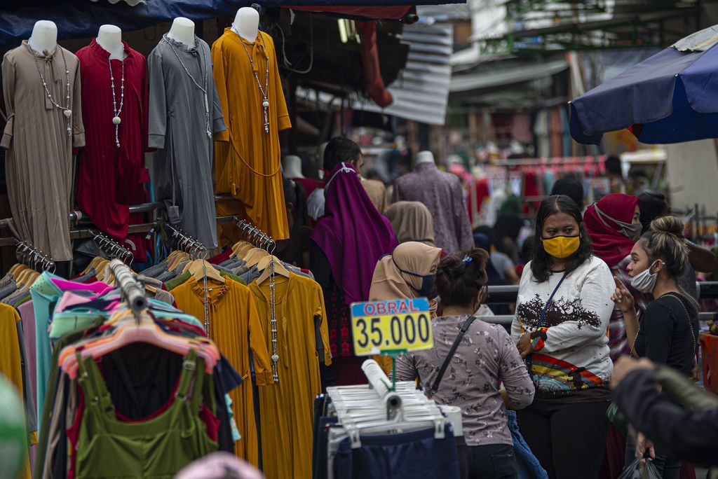 Warga berbelanja pakaian yang dijual pedagang kaki lima di Jalan Jati Baru II, Tanah Abang, Jakarta, Senin (18/5/2020). Meski kawasan niaga Pasar Tanah Abang telah tutup selama masa Pembatasan Sosial Berskala Besar (PSBB), namun sebagian oknum pedagang tetap menggelar lapaknya di sejumlah titik seperti di atas trotoar dan di gang perkampungan setempat. ANTARA FOTO/Aditya Pradana Putra/wsj.