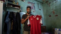 Mahrous Mahmoud memamerkan jersey Timnas Mesir kebanggaannya di depan kamera.
