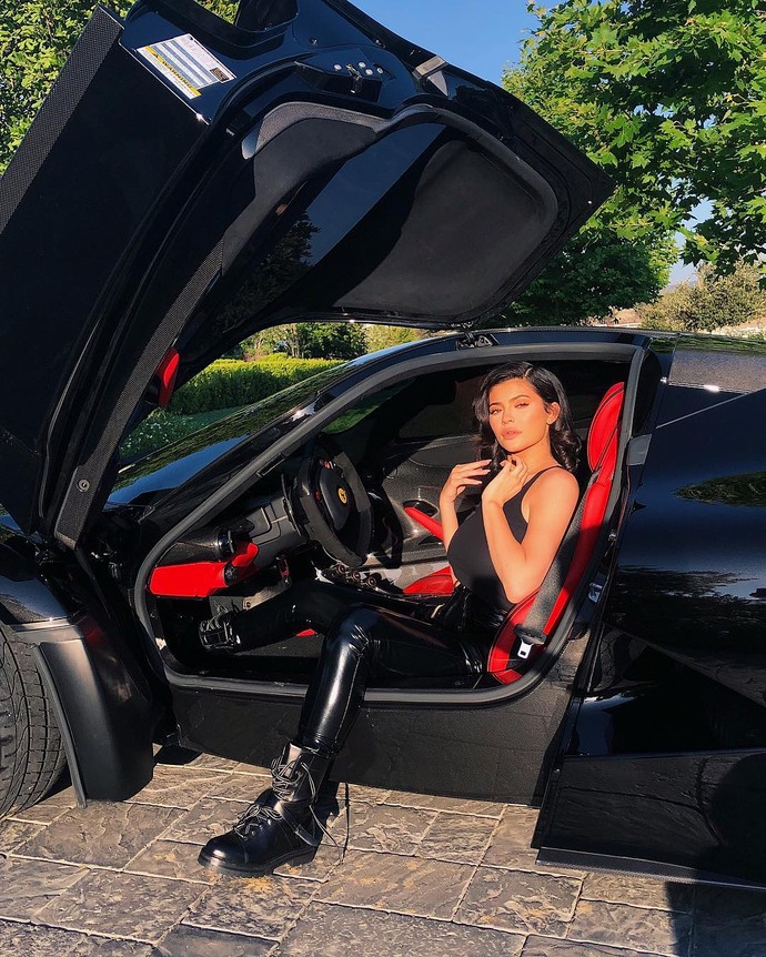 Pose Kylie Jenner di depan mobil mewah