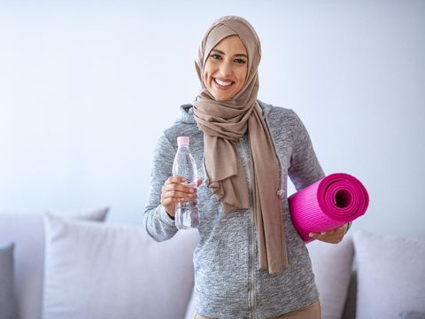 Muslim woman preparing for workout. Young muslim woman ready to running. Islamic woman resting and drinking water. Portrait of muslim woman likes her active life.