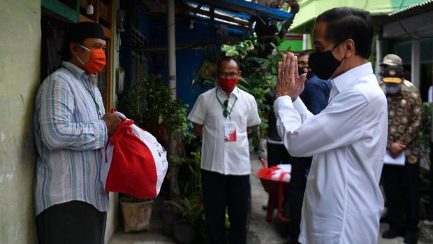 Presiden Joko Widodo (kanan) memberi salam kepada warga saat meninjau proses distribusi sembako tahap ketiga bagi masyarakat kurang mampu dan terdampak COVID-19 di kawasan Johar Baru, Jakarta Pusat, Senin (18/5/2020). ANTARA FOTO/Sigid Kurniawan/wsj.