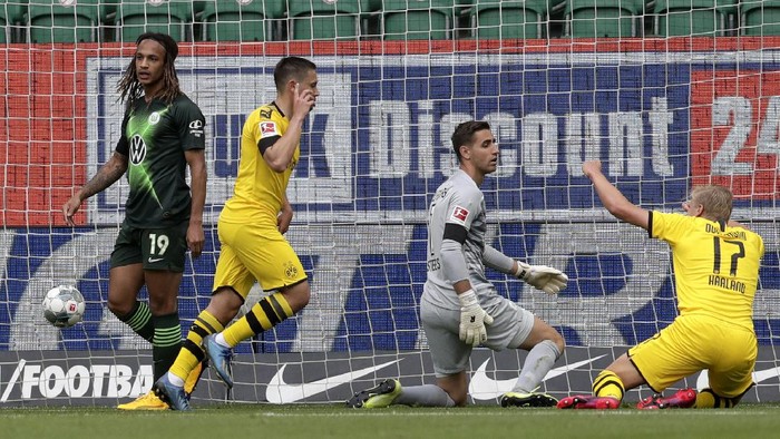 WOLFSBURG, GERMANY - MAY 23: Raphael Guerreiro of Borussia Dortmund celebrates after scoring his sides first goal past goalkeeper Koen Casteels of Wolfsburg during the Bundesliga match between VfL Wolfsburg and Borussia Dortmund at Volkswagen Arena on May 23, 2020 in Wolfsburg, Germany. (Photo by Michael Sohn/Pool via Getty Images)