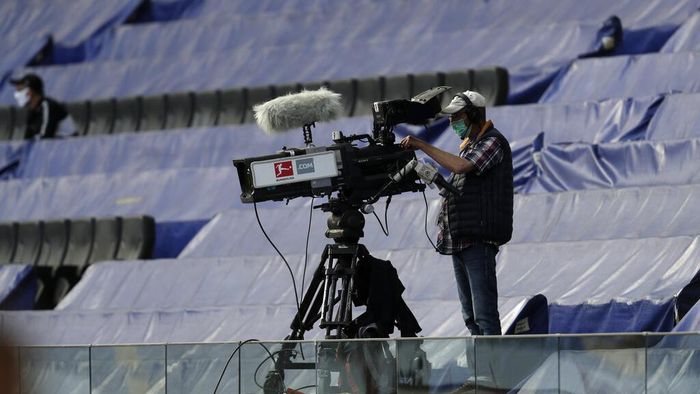 Bundesliga 2019/2020 Cameraman wearing a face mask looks not his camera standing by covered seats prior the German Bundesliga soccer match between Eintracht Frankfurt and Borussia Moenchengladbach in Frankfurt, Germany, Saturday, March 16, 2020. The German Bundesliga becomes the worlds first major soccer league to resume after a two-month suspension because of the coronavirus pandemic. (AP Photo/Michael Probst, Pool)