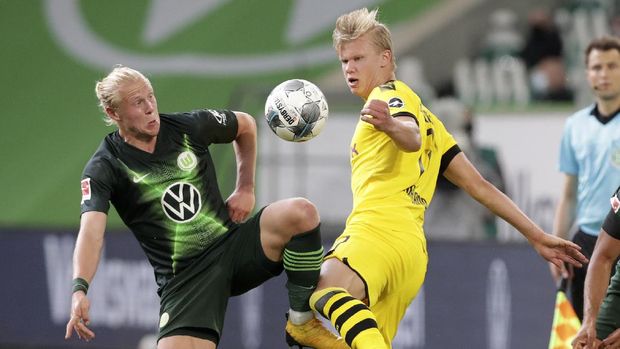 Wolfsburg's Xaver Schlager, left, vies for the ball with Dortmund's Erling Haaland during the German Bundesliga soccer match between VfL Wolfsburg and Borussia Dortmund in Wolfsburg, Germany, Saturday, May 23, 2020. The German Bundesliga is the world's first major soccer league to resume after a two-month suspension because of the coronavirus pandemic. (AP Photo/Michael Sohn, Pool)