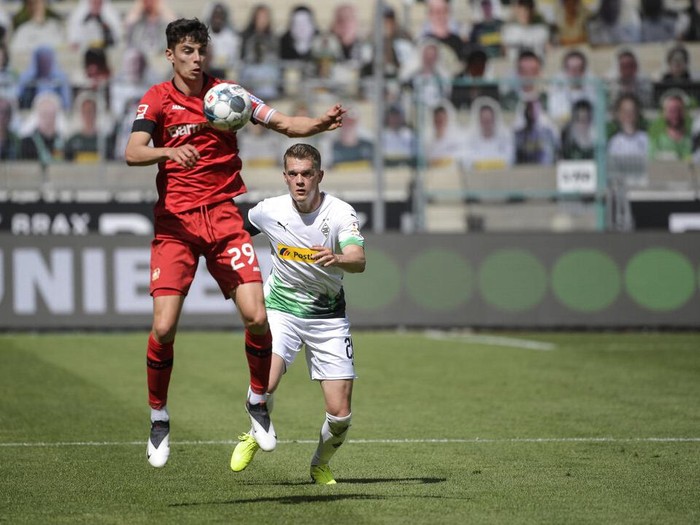 Leverkusens German midfielder Kai Havertz, left, and Moenchengladbachs German defender Matthias Ginter vie for the ball during the German Bundesliga soccer match between Borussia Moenchengladbach and Leverkusen, in Moenchengladbach, Germany, Saturday, May 23, 2020. (Ina Fassbender Pool Photo via AP)
