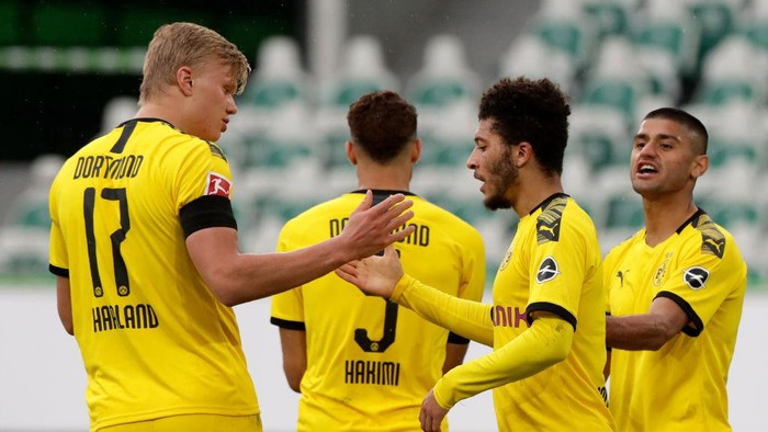WOLFSBURG, GERMANY - MAY 23: Jadon Sancho of Borussia Dortmund celebrates with Erling Haaland after Achraf Hakimi (Obscured) scored their sides second goal during the Bundesliga match between VfL Wolfsburg and Borussia Dortmund at Volkswagen Arena on May 23, 2020 in Wolfsburg, Germany. (Photo by Michael Sohn/Pool via Getty Images)