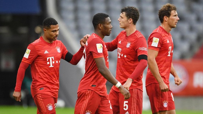 MUNICH, GERMANY - MAY 23: Serge Gnabry, Benjamin Pavard and Alphonso Davies of FC Bayern Muenchen celebrate their sides fifth goal which came through a Martin Hinteregger (not pictured) own goal during the Bundesliga match between FC Bayern Muenchen and Eintracht Frankfurt at Allianz Arena on May 23, 2020 in Munich, Germany. (Photo by Andreas Gebert/Pool via Getty Images)