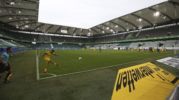 Dortmund's Raphael Guerreiro takes a corner kick during the German Bundesliga soccer match between VfL Wolfsburg and Borussia Dortmund in Wolfsburg, Germany, Saturday, May 23, 2020. The German Bundesliga is the world's first major soccer league to resume after a two-month suspension because of the coronavirus pandemic. (AP Photo/Michael Sohn, Pool)