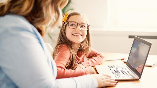Mother and daughter Having fun with laptop at home