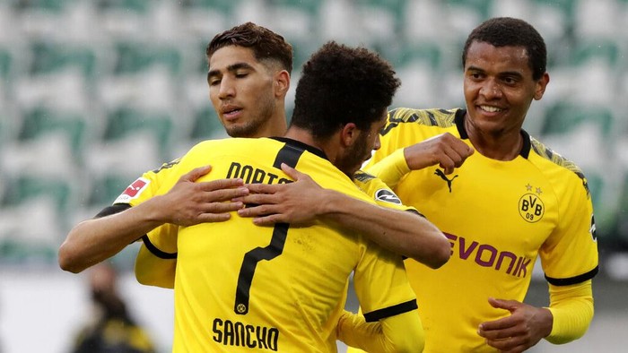 Dortmunds Achraf Hakimi, left, celebrates with Jadon Sancho after scoring his sides second goal during the German Bundesliga soccer match between VfL Wolfsburg and Borussia Dortmund in Wolfsburg, Germany, Saturday, May 23, 2020. The German Bundesliga is the worlds first major soccer league to resume after a two-month suspension because of the coronavirus pandemic. (AP Photo/Michael Sohn, Pool)