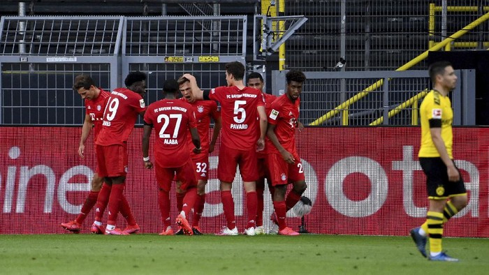 Munichs scorer Joshua Kimmich, center, and his teammates celebrate the opening goal during the German Bundesliga soccer match between Borussia Dortmund and FC Bayern Munich in Dortmund, Germany, Tuesday, May 26, 2020. The German Bundesliga is the worlds first major soccer league to resume after a two-month suspension because of the coronavirus pandemic. (Federico Gambarini/DPA via AP, Pool)