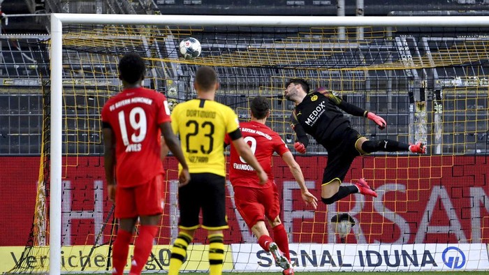 Dortmunds goalkeeper Roman Buerki, right, fails to safe a shot by Munichs Joshua Kimmich during the German Bundesliga soccer match between Borussia Dortmund and FC Bayern Munich in Dortmund, Germany, Tuesday, May 26, 2020. The German Bundesliga is the worlds first major soccer league to resume after a two-month suspension because of the coronavirus pandemic. (Federico Gambarini/DPA via AP, Pool)
