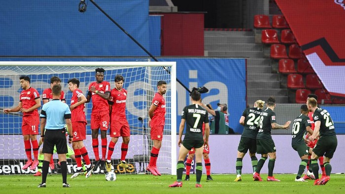 Wolfsburgs Maximilian Arnold, right, scores his sides second goal during the German Bundesliga soccer match between Bayer 04 Leverkusen and VfL Wolfsburg in Leverkusen, Germany, Tuesday, May 26, 2020. The German Bundesliga is the worlds first major soccer league to resume after a two-month suspension because of the coronavirus pandemic. (Marius Becker/DPA via AP, Pool)