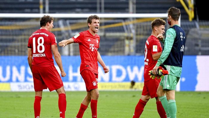 Borussia Dortmund vs Bayern Munich Munichs Thomas Mueller, second left, celebrates after the German Bundesliga soccer match between Borussia Dortmund and FC Bayern Munich in Dortmund, Germany, Tuesday, May 26, 2020. The German Bundesliga is the worlds first major soccer league to resume after a two-month suspension because of the coronavirus pandemic. (Federico Gambarini/DPA via AP, Pool)