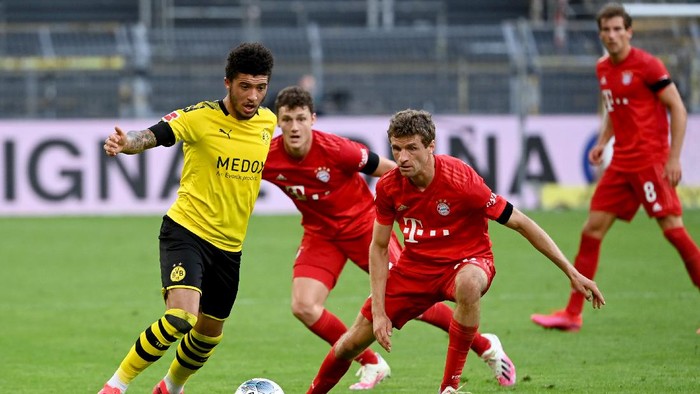 DORTMUND, GERMANY - MAY 26: Jadon Sancho of Borussia Dortmund is challenged by Thomas Muller of Bayern Munich during the Bundesliga match between Borussia Dortmund and FC Bayern Muenchen at Signal Iduna Park on May 26, 2020 in Dortmund, Germany. (Photo by Federico Gambarini/Pool via Getty Images)