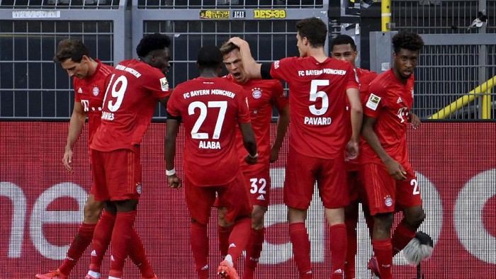Munichs scorer Joshua Kimmich, center, and his teammats celebrate the opening goal during the German Bundesliga soccer match between Borussia Dortmund and FC Bayern Munich in Dortmund, Germany, Tuesday, May 26, 2020. The German Bundesliga is the worlds first major soccer league to resume after a two-month suspension because of the coronavirus pandemic. (Federico Gambarini/DPA via AP, Pool)