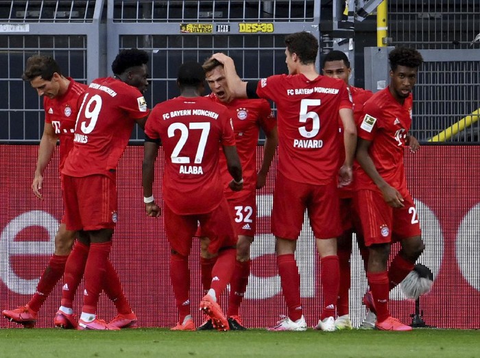 Munichs scorer Joshua Kimmich, center, and his teammats celebrate the opening goal during the German Bundesliga soccer match between Borussia Dortmund and FC Bayern Munich in Dortmund, Germany, Tuesday, May 26, 2020. The German Bundesliga is the worlds first major soccer league to resume after a two-month suspension because of the coronavirus pandemic. (Federico Gambarini/DPA via AP, Pool)